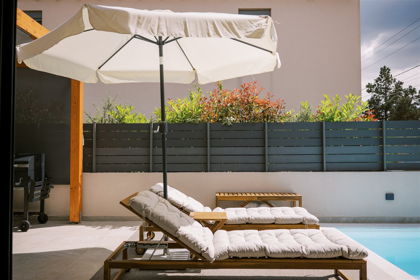 Sun loungers and pool at Odysseas Seaside Escape